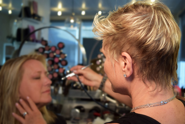 Professional makeup artist applying airbrush application